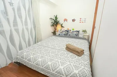 a bedroom with a bed with a gray and white blanket at Spring Apartment Shinjuku in Tokyo
