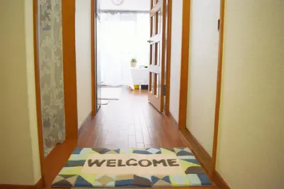 a hallway with a welcome rug on the floor at Spring Apartment Shinjuku in Tokyo