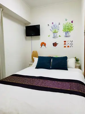 a bedroom with a bed and a tv on the wall at Spring Apartment Shinjuku in Tokyo