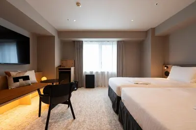 a hotel room with two beds and a desk at Richmond Hotel Asakusa in Tokyo