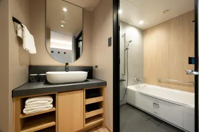 a bathroom with a sink and a mirror and a tub at Richmond Hotel Asakusa in Tokyo