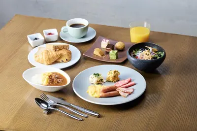 a table with plates of breakfast food and a cup of coffee at Hamacho Hotel Tokyo in Tokyo