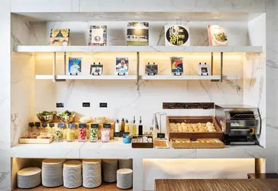 a bakery with a counter with plates and food at Hamacho Hotel Tokyo in Tokyo
