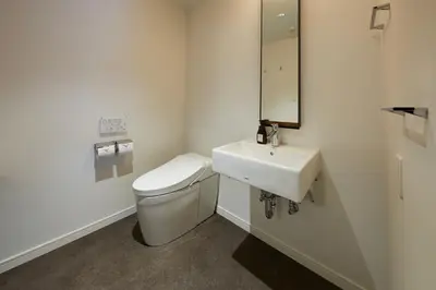 a white bathroom with a toilet and a sink at Hamacho Hotel Tokyo in Tokyo