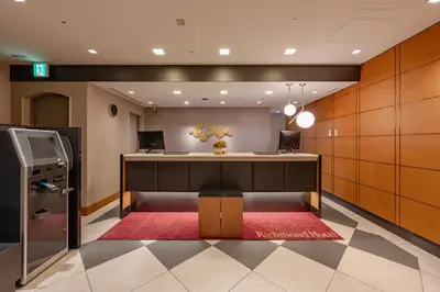 an office lobby with a desk and a red rug at Richmond Hotel Tokyo Mejiro in Tokyo