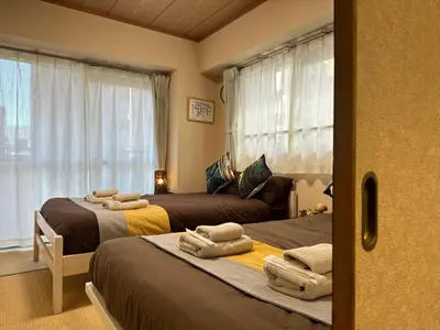 a bedroom with two beds with towels on them at nestay apartment tokyo akihabara 2A in Tokyo