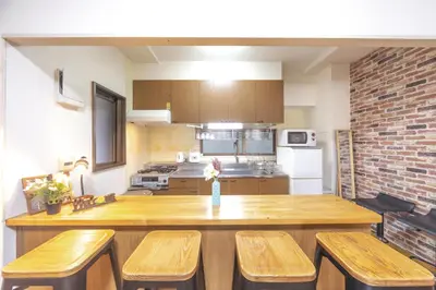 a kitchen with a wooden table and wooden chairs at nestay apartment tokyo akihabara 2A in Tokyo