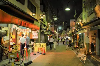a group of people walking down a street at night at Alo BnB 2 - Near NIPPORI, YANAKA GINZA, UENO, SENSOJI - Self check-in in Tokyo