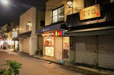 a store with doors on a street at night at Alo BnB 2 - Near NIPPORI, YANAKA GINZA, UENO, SENSOJI - Self check-in in Tokyo