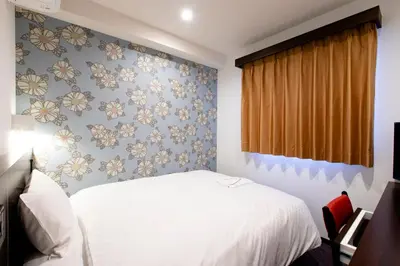 a bedroom with a white bed and floral wallpaper at Hotel Wing International Tokyo Akabane in Tokyo
