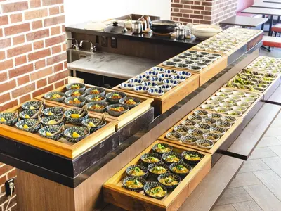 a row of trays filled with different types of food at Hotel Wing International Tokyo Akabane in Tokyo