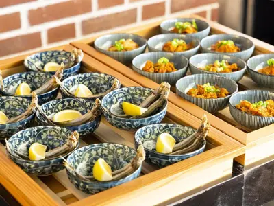 a tray full of bowls of food with lemons in them at Hotel Wing International Tokyo Akabane in Tokyo