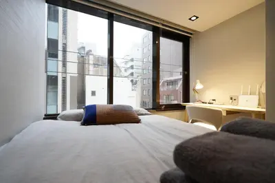 a bedroom with a bed and a large window at Real Life Kudanshita in Tokyo