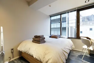 a bedroom with a bed with towels on it at Real Life Kudanshita in Tokyo