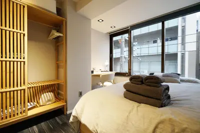 a bedroom with a bed with two towels on it at Real Life Kudanshita in Tokyo