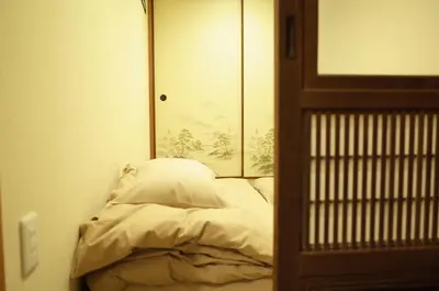 a small bed in a room with a mirror at bnb+ Asakusa Kuramae in Tokyo
