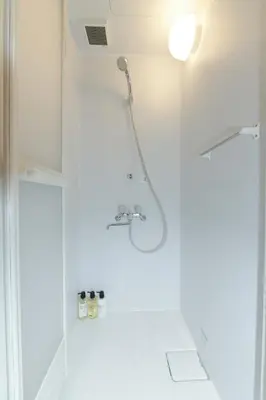 a shower in a bathroom with a glass door at bnb+ Asakusa Kuramae in Tokyo