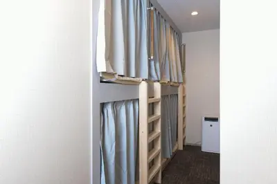 a walk in closet with blue curtains at bnb+ Asakusa Kuramae in Tokyo
