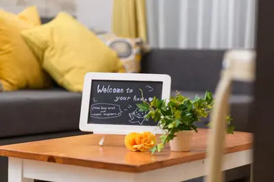 a table with a laptop with a welcome to your home chalkboard at Suiren Residential Suite Tokyo in Tokyo