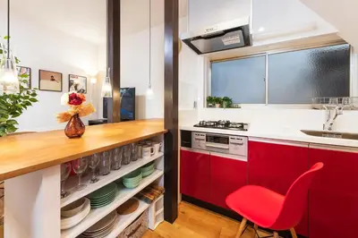 a kitchen with red cabinets and a red chair at Suiren Residential Suite Tokyo in Tokyo