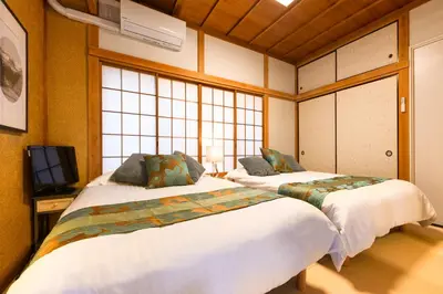 two beds in a room with two windows at Suiren Residential Suite Tokyo in Tokyo