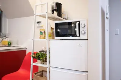 a microwave on top of a refrigerator in a kitchen at Suiren Residential Suite Tokyo in Tokyo