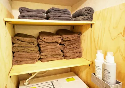 a pile of towels on a shelf in a bathroom at Shibuya apartment SHINSEN in Tokyo