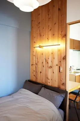 a bedroom with a bed and a wooden wall at Shibuya apartment SHINSEN in Tokyo