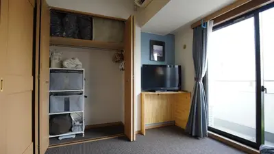 a living room with a tv and a sliding door at Shibuya apartment SHINSEN in Tokyo