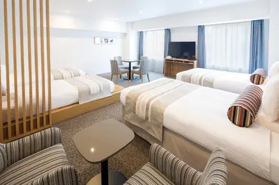 a hotel room with two beds and a table at HOTEL MYSTAYS PREMIER Omori in Tokyo