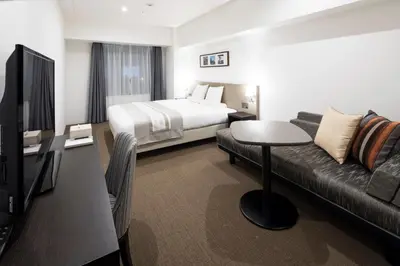 a hotel room with a bed and a couch at HOTEL MYSTAYS PREMIER Omori in Tokyo