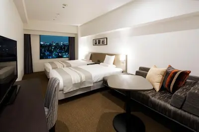 a hotel room with a bed and a couch at HOTEL MYSTAYS PREMIER Omori in Tokyo
