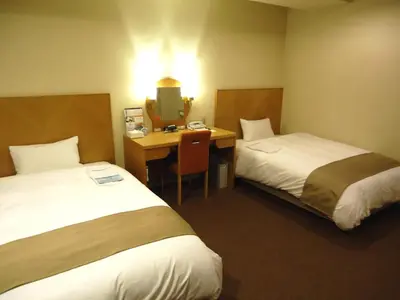 a hotel room with two beds and a desk at Chisun Inn Keikyu Kamata in Tokyo