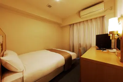 a hotel room with a bed and a desk with a television at Chisun Inn Keikyu Kamata in Tokyo
