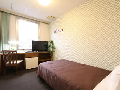 a bedroom with a bed and a desk with a computer at HOTEL LiVEMAX BUDGET Tokyo Kiba in Tokyo