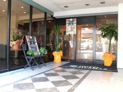a store front with potted plants in front of it at HOTEL LiVEMAX BUDGET Tokyo Kiba in Tokyo