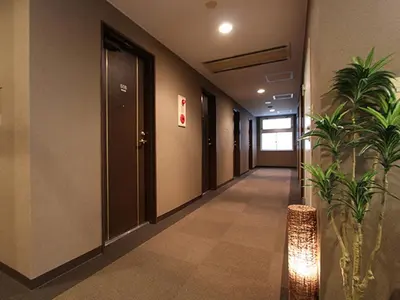 a hallway with a plant in a building at HOTEL LiVEMAX BUDGET Tokyo Kiba in Tokyo