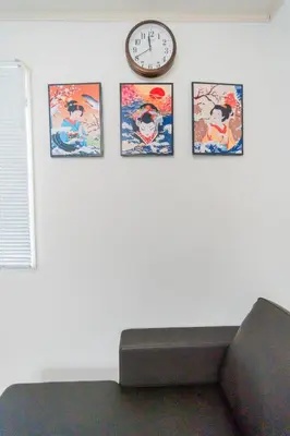 a clock on a wall with four pictures on it at Tokyo Private House \u5927\u585a\u306e\u5bbf in Tokyo