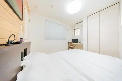 a bedroom with a white bed and a mirror at Tokyo Private House \u5927\u585a\u306e\u5bbf in Tokyo