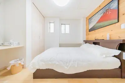 a bedroom with a white bed with a wooden headboard at Tokyo Private House \u5927\u585a\u306e\u5bbf in Tokyo