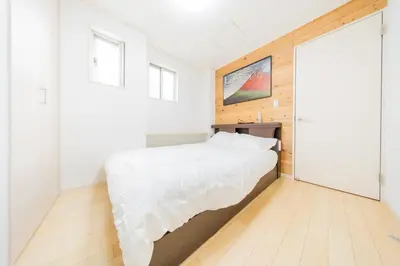 a bedroom with a white bed and a large window at Tokyo Private House \u5927\u585a\u306e\u5bbf in Tokyo