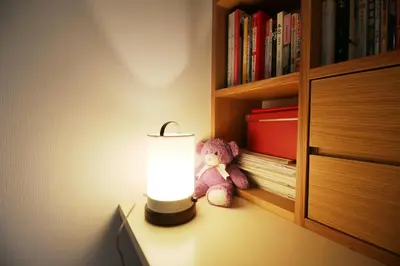 a teddy bear sitting on a table next to a lamp at Uhome Ikebukuro Villa 2 in Tokyo