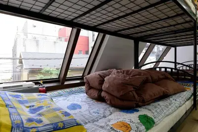 a bed in a room with a large window at Yushima Okachimachi Hotel in Tokyo