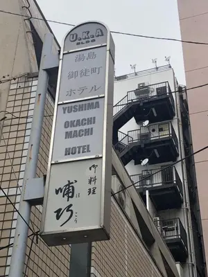 a sign for a hotel in front of a building at Yushima Okachimachi Hotel in Tokyo
