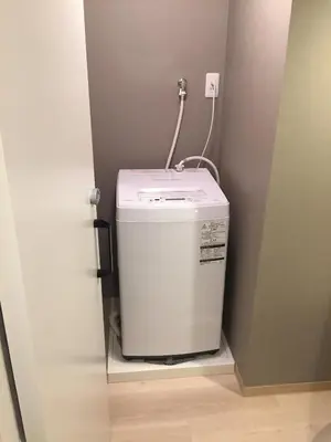 a washing machine in a corner of a room at Yushima Okachimachi Hotel in Tokyo