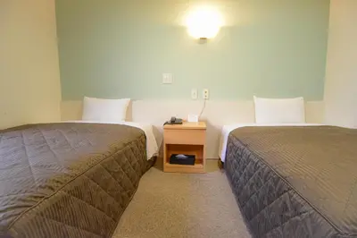 a hotel room with two beds and a night stand at Kamata Inn Social in Tokyo