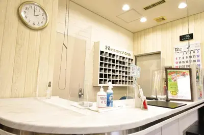 a store counter with a clock on the wall at Kamata Inn Social in Tokyo