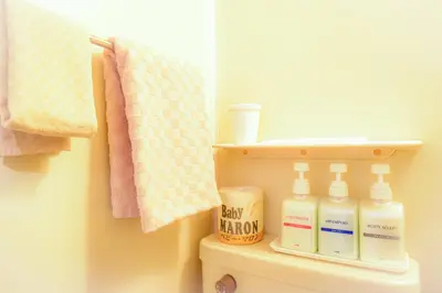 a bathroom with a shelf on the back of a toilet at Kamata Inn Social in Tokyo
