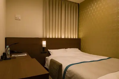 a hotel room with a bed and a desk and a bed sidx sidx at Tosei Hotel Cocone Ueno in Tokyo
