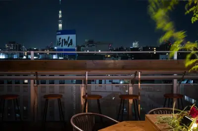 a table and chairs on a balcony at night at Tosei Hotel Cocone Ueno in Tokyo